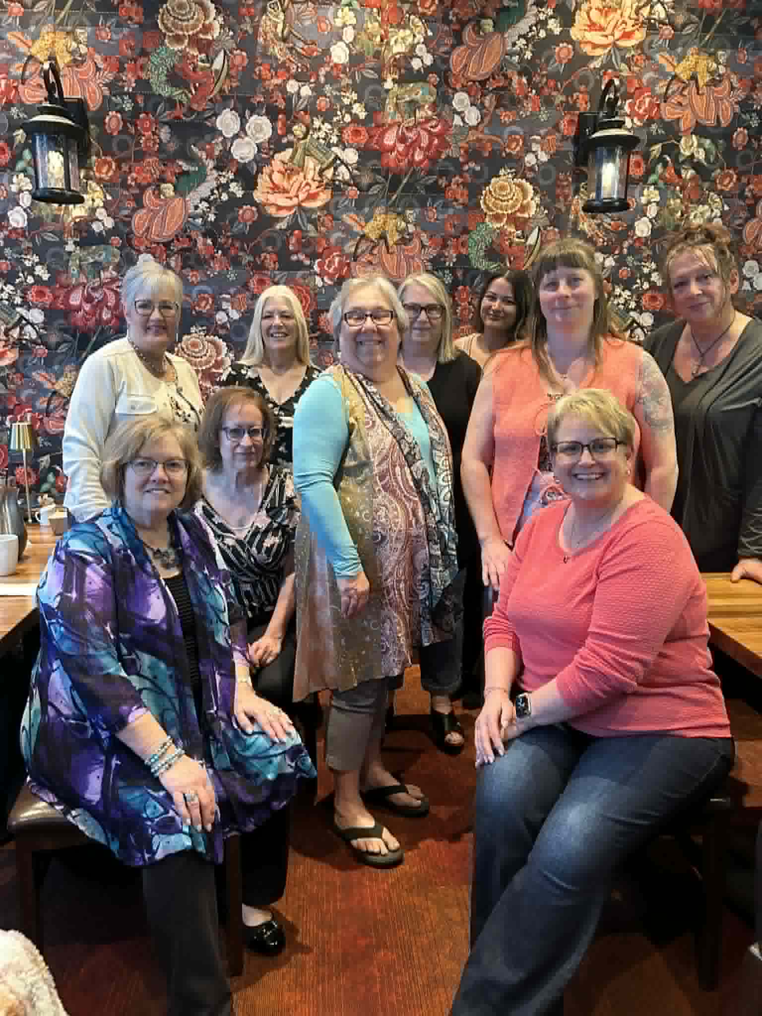 group of entrepreneurial women sitting around a table for their monthly women's business networking lunch